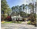 Charming two-story home with brick and white siding, a covered carport, and mature trees at 1305 Lennox Pl, Raleigh, NC 27612