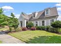 Charming traditional home boasting a lush green lawn, mature landscaping, and inviting curb appeal with detailed trim at 1342 Briar Chapel Pkwy, Chapel Hill, NC 27516