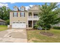 Inviting two-story home features a well-kept lawn, attached garage, and welcoming covered porch at 143 Thornbury St, Clayton, NC 27527