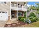 Inviting front porch with a stone wall, a wreath on the door, and beautiful landscaping at 143 Thornbury St, Clayton, NC 27527