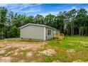 Back of a single Gathering home with gray siding and a lush green backdrop at 150 Will Woods Way, Franklinton, NC 27525