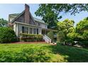 Side view of the home with a well-manicured lawn, mature trees, and a cozy porch at 1700 St Marys St, Raleigh, NC 27608