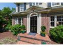 Close up of front door, showing brickwork, black door, and potted plants at 1700 St Marys St, Raleigh, NC 27608