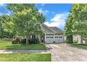 Inviting home exterior with two-car garage, lush trees, and a well-manicured lawn at 1808 Pennypacker Ln, Durham, NC 27703