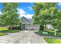 Attractive home featuring a well-kept lawn, mature trees, and a driveway leading to a two-car garage at 1808 Pennypacker Ln, Durham, NC 27703