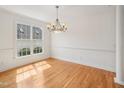 Sun-filled dining room with hardwood floors, bright light fixture, and large window at 1817 Wysong Ct, Raleigh, NC 27612