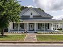 Inviting two-story white home boasts a charming front porch, symmetrical design, and well-manicured lawn at 212 W Church St, Benson, NC 27504