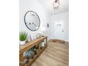 Bright foyer featuring wood floors, decorative table with plant, and a stylish round mirror at 226 Castle Pond Way, Fuquay Varina, NC 27526