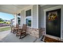 Inviting front porch with rocking chairs, decorative wreath, and a welcoming doormat at 226 Castle Pond Way, Fuquay Varina, NC 27526