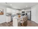 Modern kitchen featuring white cabinets, stainless steel appliances, and a spacious island with seating at 287 South Breeze Way, Fuquay Varina, NC 27526