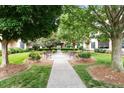 Beautiful courtyard with lush greenery, mature trees, benches and manicured landscaping at 300 Finsbury St # 109, Durham, NC 27703