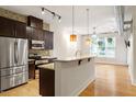 Modern kitchen with stainless steel appliances, granite countertops, and hardwood floors opening to living area at 300 Finsbury St # 109, Durham, NC 27703