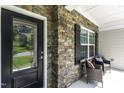 Cozy front porch with stone accents, a seating area, and a view of the landscaped yard at 301 Sawgrass Ct, Mebane, NC 27302