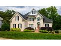 Elegant brick home featuring a well-maintained lawn and lush greenery at 3021 Glenwood Dr, Durham, NC 27705