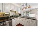 Well-lit kitchen with granite countertops, stone backsplash, stainless steel appliances, and fireplace view at 304 Cayman Ave, Holly Springs, NC 27540