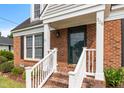 Inviting front porch with brick steps, white railings, and a charming entryway at 304 Westfield Dr, Dunn, NC 28334