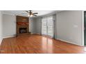 Bright living room with a brick fireplace, hardwood floors, and a sliding glass door at 304 Westfield Dr, Dunn, NC 28334