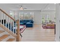 Bright living room with hardwood floors, large windows, and stylish blue sectional sofa at 309 Highland Forest Dr, Fuquay Varina, NC 27526