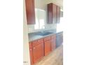 A functional kitchen featuring dark cabinets, a stainless steel faucet and essential appliances at 3207 Geary Trl, Raleigh, NC 27610