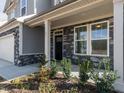 Up close view of the home's entrance, showcasing stone accents and manicured landscaping at 417 Hipwood Dr, Zebulon, NC 27597