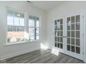 Inviting living room featuring glass paneled doors, neutral walls, and bright windows at 417 Hipwood Dr, Zebulon, NC 27597