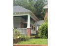 Bungalow front porch with columns, brick foundation, and overgrown front yard at 431 Charles St, Henderson, NC 27536