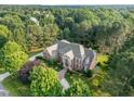 Beautiful aerial view of a brick house surrounded by mature trees and lush landscaping at 5768 Cavanaugh Dr, Raleigh, NC 27614