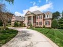 Stunning exterior view of the estate featuring a brick facade and beautifully landscaped front yard at 5768 Cavanaugh Dr, Raleigh, NC 27614