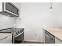 Close up of modern kitchen with stainless steel oven, microwave and white backsplash at 600 S Duke St # 24, Durham, NC 27701