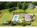 Wide aerial view showcasing the large lot, in-ground pool, backyard amenities, and surrounding greenery at 6250 Moinear Ln, Chapel Hill, NC 27514
