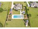 Complete aerial view of the backyard, featuring the pool, cabana, meticulous landscaping, and lush greenery at 6250 Moinear Ln, Chapel Hill, NC 27514