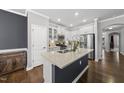 Modern kitchen with white cabinetry, stainless steel appliances, quartz countertops, and a central island at 6313 Kayton St, Raleigh, NC 27616