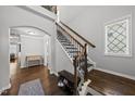 Elegant staircase with wooden steps, iron railings, and natural light from a nearby window at 6313 Kayton St, Raleigh, NC 27616