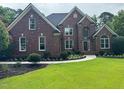 Charming brick two-story home with a manicured lawn and a walkway leading to the front door at 6553 Vintage Ridge Ln, Fuquay Varina, NC 27526
