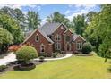 Stunning brick home featuring mature landscaping, a well-manicured lawn, and a classic architectural design at 6553 Vintage Ridge Ln, Fuquay Varina, NC 27526