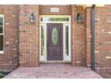 Elegant front door with decorative glass, sidelights, and outdoor lanterns, framed by brick at 6553 Vintage Ridge Ln, Fuquay Varina, NC 27526