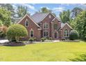 Beautifully designed brick home showcasing a lush green lawn and a professionally landscaped yard at 6553 Vintage Ridge Ln, Fuquay Varina, NC 27526
