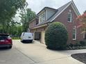View of the rear of the home with a two-car garage and a paved driveway at 6553 Vintage Ridge Ln, Fuquay Varina, NC 27526