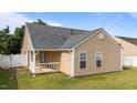 A view of the home's exterior featuring a quaint covered patio and lush green backyard at 6920 Moss Creek Way, Rocky Mount, NC 27804