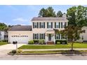 Traditional two-story home with attached garage, American flag, and well-maintained front lawn and garden at 6924 Coventry Ridge Rd, Raleigh, NC 27616