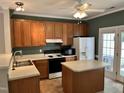 Kitchen featuring wood cabinets, white appliances, and island at 7331 Bonnie Ridge Ct, Raleigh, NC 27615