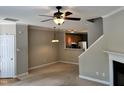 Living room with ceiling fan, fireplace, open to kitchen and staircase at 7331 Bonnie Ridge Ct, Raleigh, NC 27615