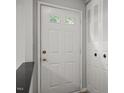 Interior view of a classic white front door with sidelights, offering a glimpse of the exterior at 7731 Kingsberry Ct, Raleigh, NC 27615
