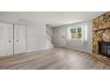 Bright living room with wood-look flooring, stone fireplace, and a staircase at 7731 Kingsberry Ct, Raleigh, NC 27615