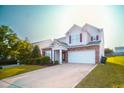 Two-story home featuring stone accents, attached two car garage, and a manicured lawn at 8021 Wesley Farm Dr, Raleigh, NC 27616