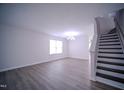 Open living space with hardwood floors, a chandelier, and large windows at 8021 Wesley Farm Dr, Raleigh, NC 27616