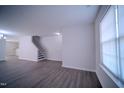 Spacious living room with hardwood floors, a staircase and bright windows at 8021 Wesley Farm Dr, Raleigh, NC 27616