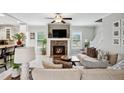 Bright living room featuring a cozy fireplace, ceiling fan, and neutral décor, perfect for relaxing at 9300 Lake Wheeler Rd, Fuquay Varina, NC 27526
