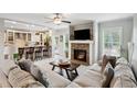 Inviting living room featuring a stone fireplace, plush seating, and an open layout to the kitchen at 9300 Lake Wheeler Rd, Fuquay Varina, NC 27526