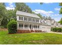 Beautiful two-story home boasts a welcoming front porch and lush green lawn at 9425 Brimstone Ln, Raleigh, NC 27613